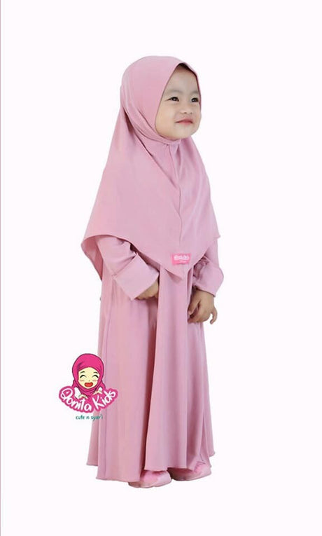 a little girl in a pink dress holding a cell phone 